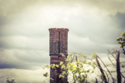 View of skyscraper against cloudy sky