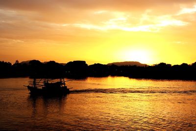 Silhouette boat in sea against sky during sunset