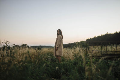 Woman in tall grass at sunset