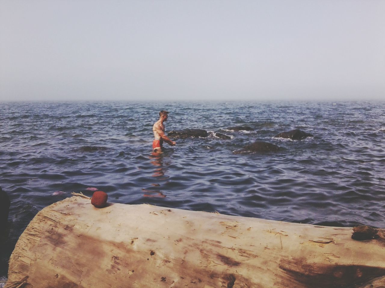 water, sea, clear sky, copy space, lifestyles, leisure activity, horizon over water, rippled, full length, nature, tranquility, beauty in nature, scenics, tranquil scene, men, day, rear view, standing