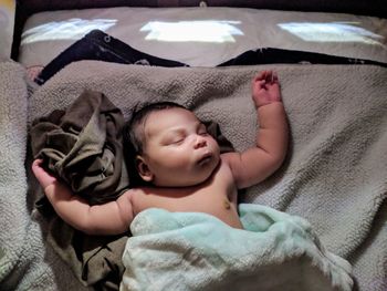 High angle view of cute baby boy sleeping on bed