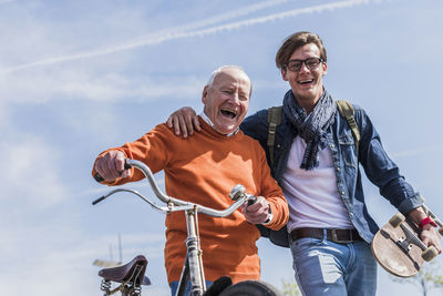 Portrait of happy senior man with adult grandson on the move