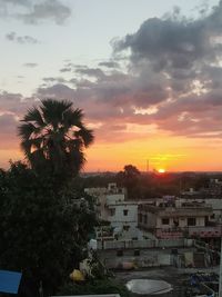 High angle view of buildings and trees against sky during sunset