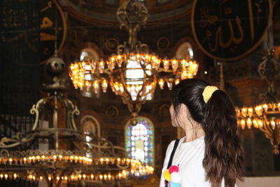 Woman looking at chandelier in church 