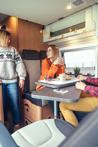 Friends having breakfast in a camper van in the morning