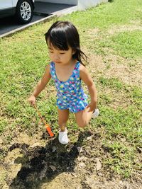 High angle view of cute girl lying on field