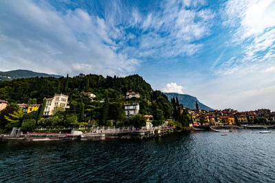 Scenic view of townscape by sea against sky