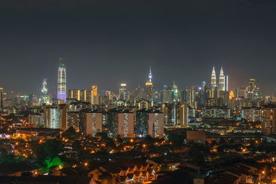 Illuminated cityscape against sky at night