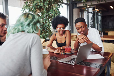 Group of multi ethnic people with alternative girl with green hair is working together