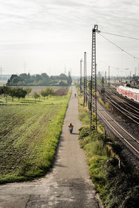 High angle view of person riding motor scooter by field on road