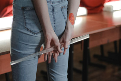 Midsection of woman holding transparent plastic stick