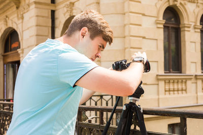 Man photographing against building