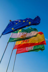 Low angle view of flag against blue sky