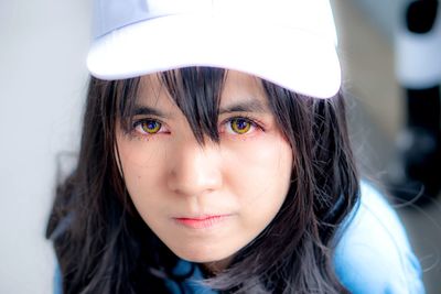 Close-up portrait of young woman wearing cap at home