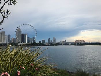 View of city by river against sky