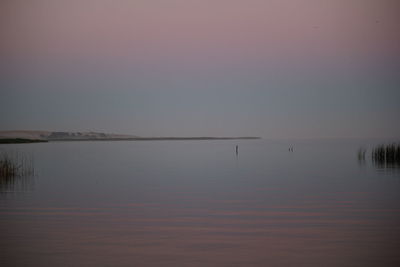 Scenic view of lake against clear sky during sunset