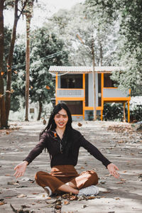 Portrait of smiling young woman sitting outdoors