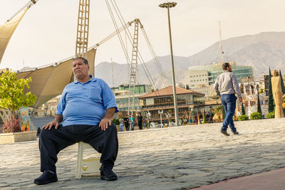 Full length of man sitting against mountain