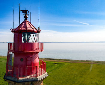 View of lighthouse by sea against sky