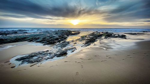 Scenic view of beach against sky during sunset