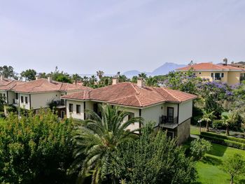 Houses and trees against sky