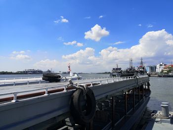 Boats moored at harbor against sky