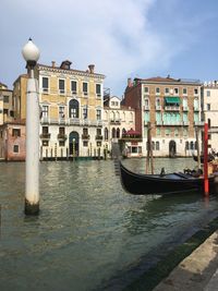 Boats moored at canal against buildings in city