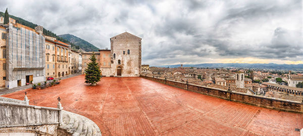 Buildings in town against cloudy sky