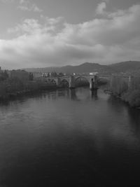 View of bridge over river against cloudy sky