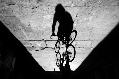 Silhouette man riding bicycle on street