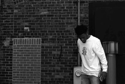 Man standing on brick wall