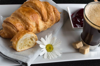 High angle view of bread with preserves and black coffee on table