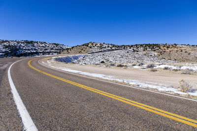 Empty road curving along arid winter landscape in springdale, utah