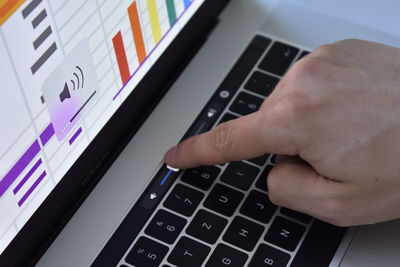 Cropped hand using laptop at table