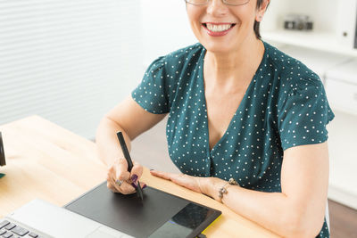 Portrait of a smiling young woman using mobile phone