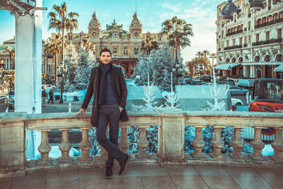 Portrait of man standing against historic building in city