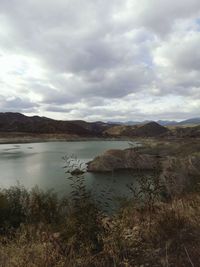 Scenic view of lake against cloudy sky