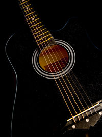 Close-up of guitar against black background