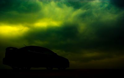 Silhouette car against sky during sunset