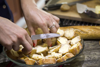 The girl prepares sandwiches from fresh bread with butter and red caviar