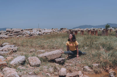 Young woman sitting on rock