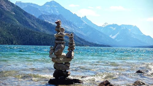 Statue against sea and mountains against sky