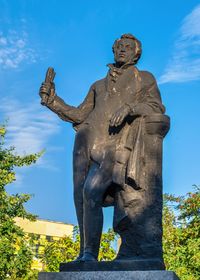 Low angle view of statue against blue sky