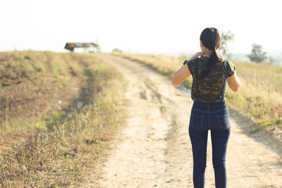 Woman standing on dirt road