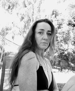 Portrait of beautiful woman against trees