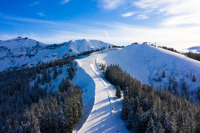 Scenic view of snow covered ski resort against sky