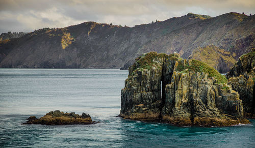 Scenic view of sea and mountains against sky