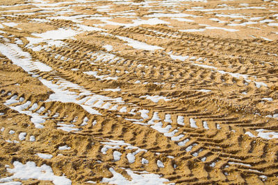 High angle view of tire tracks on field during winter