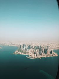 Aerial view of buildings in city against clear sky