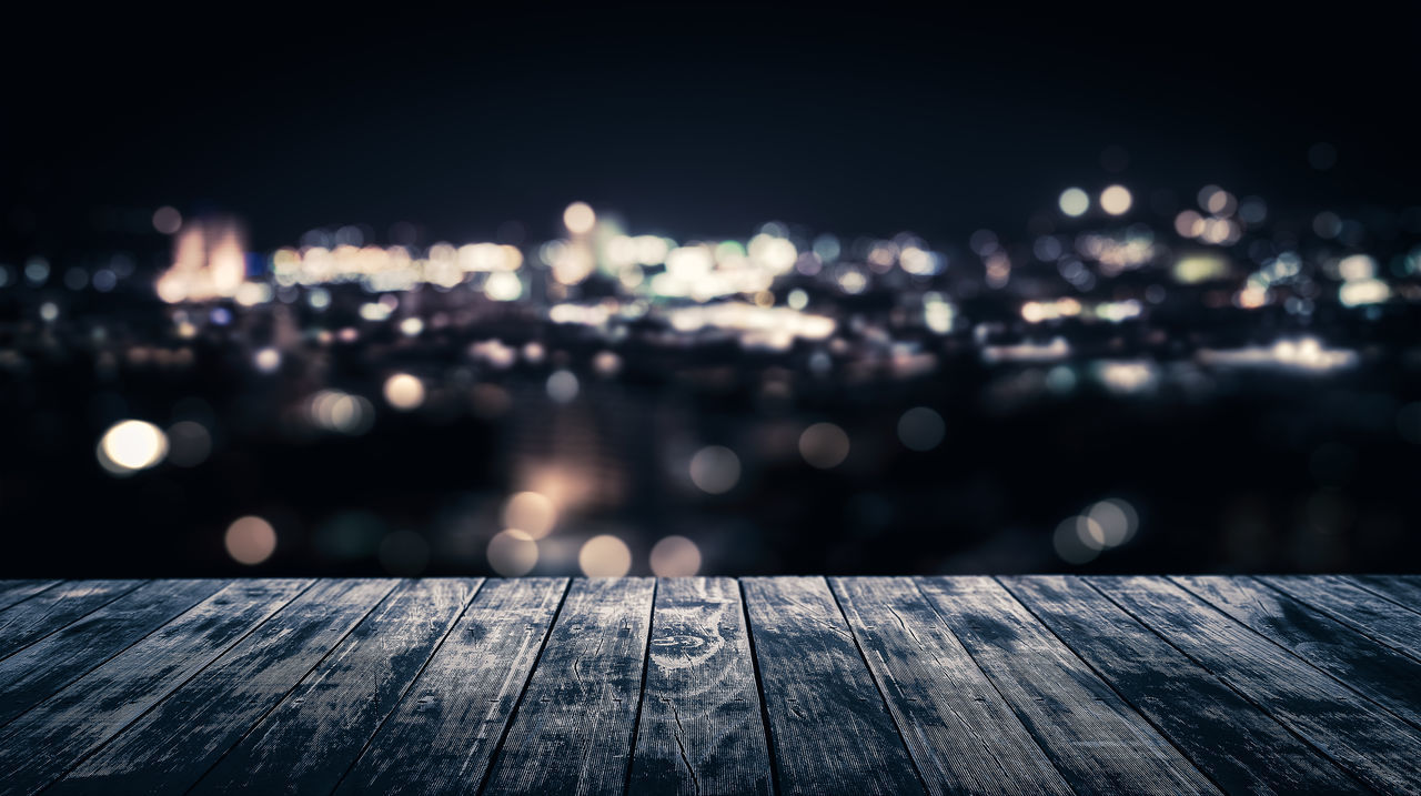 DEFOCUSED IMAGE OF ILLUMINATED PIER AT NIGHT